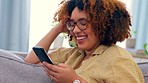 Laughing, phone and black woman on a sofa for social media, texting or funny meme in her home. Online, comic and girl relax with smartphone on couch, chatting or reading post or update in living room