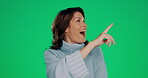 Woman, happy and green screen pointing at space for product placement in studio isolated on chromakey. Information, announcement or presentation with mockup and promotion launch with excited smile.