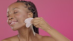 Black woman, face or gua sha in skincare beauty, routine grooming or rose quartz therapy on isolated pink background. Smile, happy or model with stone massage, holistic crystal or facial tool product