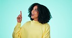 Mockup, happy and black woman point on blue background for news, announcement and review. Advertising, product placement and face of girl with hand gesture for promotion, information or marketing