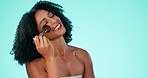 Makeup, cosmetic and female with a brush in a studio with beauty, natural and face routine. Cosmetics, self care and woman model from Mexico doing a cosmetology facial treatment by a blue background.