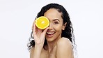 Orange fruit, skincare and face of woman in studio, clean wellness and white background. Happy model, beauty portrait and citrus fruits for natural detox diet, healthy food and aesthetic dermatology