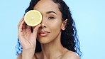 Lemon, face skincare and beauty of woman in studio, vegan wellness or blue background. Model, portrait and citrus fruits for facial cosmetics, vitamin c aesthetic or healthy natural detox dermatology