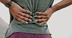 Rear view, closeup and back pain by man outdoors for fitness, training or morning cardio run. Hands, spine and injury for athletic male runner in nature while suffering with injured muscle or joint