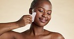 Black woman, face and facial gua sha, beauty and skincare, content and exfoliate, cosmetics tools on studio background. Healthy skin, glow and eyes closed, peace and female hand with cosmetic care