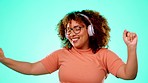 Headphones, music and dancing black woman in studio with happy turquoise background and smile with happiness. Fun, streaming service and dance, excited African person with online radio station app.