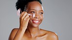 Rose quartz roller, black woman and face massage of a model with beauty facial treatment. Isolated, gray background and studio with a dermatology, skin glow and cosmetics stone tool with a smile