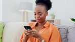 Phone, happy and black woman on a sofa typing a text message while relaxing in her living room. Happiness, smile and African female networking, browsing or scrolling on social media with a cellphone.