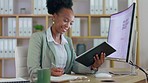 Black woman, tablet and writing business schedule for planning, strategy or digital marketing at office desk. Happy African female employee taking notes in book and touchscreen for project plan by PC