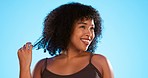 Smile, beauty and natural black woman with hair on blue background for hairstyle, treatment and healthy strand. Beauty salon, hairdresser and happy girl touch afro for wellness, grooming or cosmetics