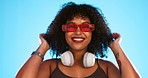 Trendy, gen z and face of a black woman in a studio with accessories, sunglasses and fashion. Happy, afro and portrait of African female model with a cool, stylish and edgy style by a blue background