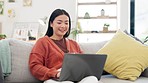 Email, typing and woman with a laptop on the sofa for communication, connection and search. Happy, working and Asian girl relaxing on the couch while on a browsing, searching and reading on computer