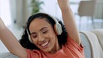 Living room dance, happiness and woman with headphones at home feeling freedom and a smile. House, happy female dancer and web song audio with energy listening and streaming music by a sofa 