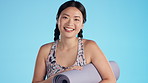 Fitness, happy and smile with asian woman and yoga mat for training, health and mindfulness. Spiritual, pilates and wellness with girl isolated on blue background for balance, positive and self care