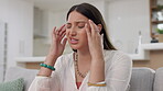 Headache, pain and sad woman is sick feeling frustrated, stress and burnout in a home or house sitting on a sofa or couch. Migraine, unhappy and female depressed with discomfort problem or issue