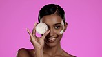 Skincare, applying and face of a woman with cream isolated on a pink background in a studio. Beauty, grooming and portrait of an Indian model showing a jar of sunscreen, lotion or moisturizer