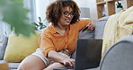 Home, laptop and woman with credit card, happy for online shopping, ecommerce or fintech easy payment at home. Black person typing bank information on her computer for finance transaction on her sofa