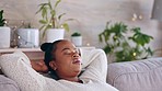 Black woman, relax and living room sofa rest with a female feeling tired in a home. Calm, resting and African person ready for a nap on a lounge couch in a house with peace and sleep in household