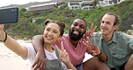 Friends, smile and selfie with peace sign on beach relaxing for profile picture, vlog or social media post in the outdoors. Happy group enjoying vacation smiling for photo, memory or capture by ocean