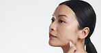 Gua sha, skincare and woman massaging face isolated on a white background in a studio. Spa, cosmetic and Asian girl with a product to massage for facial relaxation and treatment with mockup space