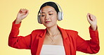 Dance smile, music headphones and Asian woman in studio isolated on a yellow background. Technology, podcast or happy female streaming, listening and dancing to radio, song and audio, sound and album