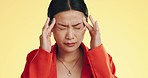 Asian woman, headache and studio with stress, migraine and hands on head to massage temple by background. Young japanese model, pain and anxiety with mental health, fatigue and burnout by backdrop