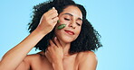 Beauty, skincare and jade roller with black woman in studio for relax, massage and cosmetics. Self care, glow and satisfaction with girl model on blue background for treatment, natural and facial