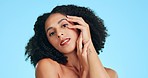 Beauty, skincare and black woman touch face for spa aesthetic, wellness and facial on blue background. Dermatology, smile and portrait of confident girl in studio for cosmetics, makeup and hair care