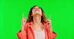 Hands, happy and woman pointing up on green screen, excited and waiting on studio background space. Smile, emoji and finger gesture by girl emoji sign for product placement or isolated copy space