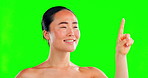 Beauty, click and swipe with an asian woman on a green screen background in studio for interactive skincare. Face, hand and button with an attractive young female on chromakey mockup for cosmetics