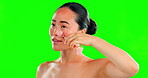 Face, beauty skincare and Asian woman with roller on green screen in studio isolated on a background mockup. Dermatology, facial and happy female model with rose quartz stone for skin treatment.