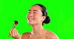 Beauty, face and makeup of Asian woman with brush on green screen in studio isolated on a background. Cosmetics,  mockup and funny female model with tool to apply foundation and powder for skin.