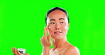 Skincare, face and woman with cream container on green screen in studio on background. Dermatology, cosmetics portrait or happy Asian female model apply product, lotion or moisturizer for skin beauty