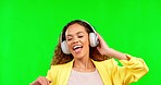 Headphones, dance and happy woman with green screen in studio with chromakey background. Music, streaming and dancing, excited person having crazy fun with online radio station or party celebration.