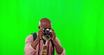 Black man, photographer and travel with camera on green screen and backpack. African senior male model on a studio background with mockup space for paparazzi, memory and photograph with mockup space