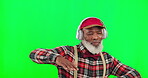 Dance, music and a senior black man with headphones on a green screen background in studio having fun. Party, fashion and funky with a happy elderly man dancing on chromakey mockup for freedom