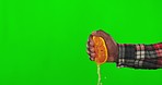 Green screen, juice and a hand squeezing an orange isolated on a studio background. Healthy, juicy and a person with a fruit for vitamin c, nutrition and diet food with mockup space on a backdrop