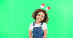 Portrait, children and cute with a girl on a green screen background in studio wearing a funky alice band. Kids, smile and innocent with an adorable little female child standing on chromakey mockup