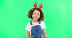 Children, christmas and a girl on a green screen background in studio wearing a reindeer antlers headband. Kids, portrait or festive with an adorable little female child feeling happy in the holidays