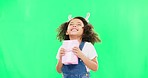 Excited, happy and face of a child with a gift isolated on a green screen studio background. Laughing, smile and face of an adorable little girl ready to open a present, package or box with mockup