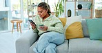 Black woman on sofa with smile, phone and coffee surfing internet, social media or web in living room. Relax, reading email or typing text, happy gen z girl on couch with smartphone on break with cup