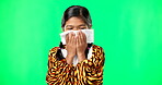 Children, covid and blowing nose with a girl on a green screen background suffering from allergies. Portrait, kids and sick with a little female child sneezing from infection, pollen or hayfever