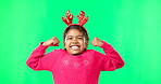 Portrait, christmas and flex with a girl on a greenscreen background in studio showing her bicep muscles. Kids, strong and playful with an adorable little female child standing on chromakey mockup