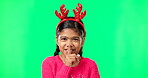 Shush, Christmas and secret with girl in green screen studio for holiday, gossip and gift. Surprise, festive and announcement with child isolated in background for celebration, privacy and present 