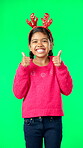 Child portrait, christmas and thumbs up on green screen for motivation or mindset. Smile of girl kid on studio background with antlers headband excited for holiday celebration thank you or like emoji
