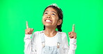 Green screen, mockup and child pointing up excited, happy and isolated in a studio background. Deal, sale and young girl or kid hands showing at brand, product placement or branding logo
