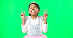 Little girl, princess and smile with peace sign on green screen in joyful happiness against a studio background. Portrait of happy adorable child or kid smiling showing peaceful hand signs on mockup