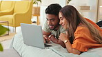 Laptop, video and a couple lying on a bed in the bedroom of their home together to relax while bonding. Computer, internet or movie with a man and woman resting in their house over the weekend