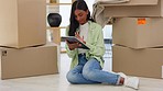 Boxes, digital tablet and woman on floor after moving into new house, happy and content. Internet, search and Indian female homeowner browsing for creative interior idea while relaxing in living room