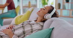 Relax, headphones and woman on sofa for music streaming, mental health and sleeping for office wellness. Young person in lounge or couch listening to calm or zen radio on audio technology or internet